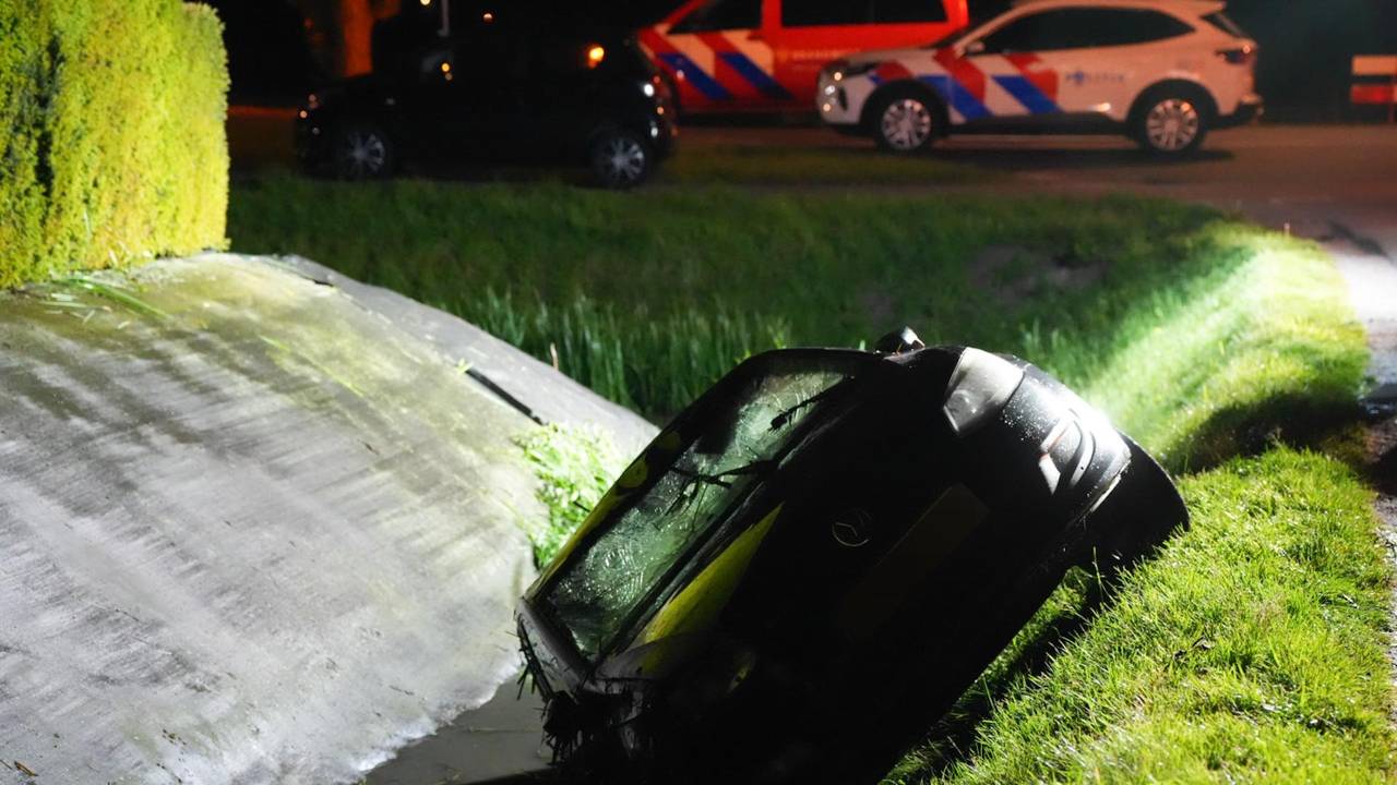 Auto op zijn kop in sloot, eigenaar staat thuis onder de douche