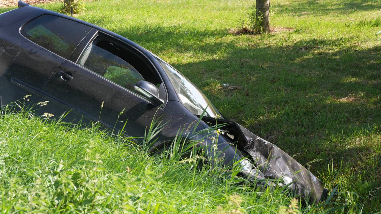 Een auto belandde na de botsing in Werkendam in een sloot (foto: Erik Haverhals/Persbureau Heitink).