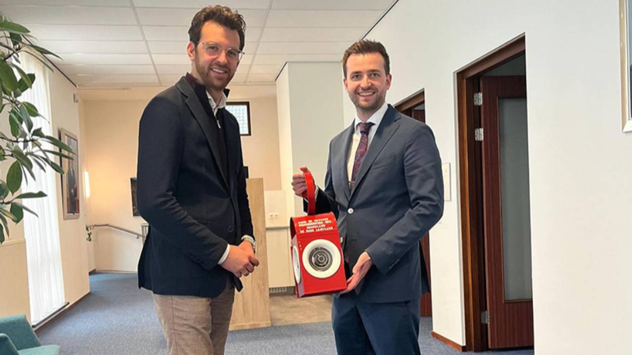 De burgemeester van Katwijk (links) krijgt de lantaarn van burgemeester Heldens.