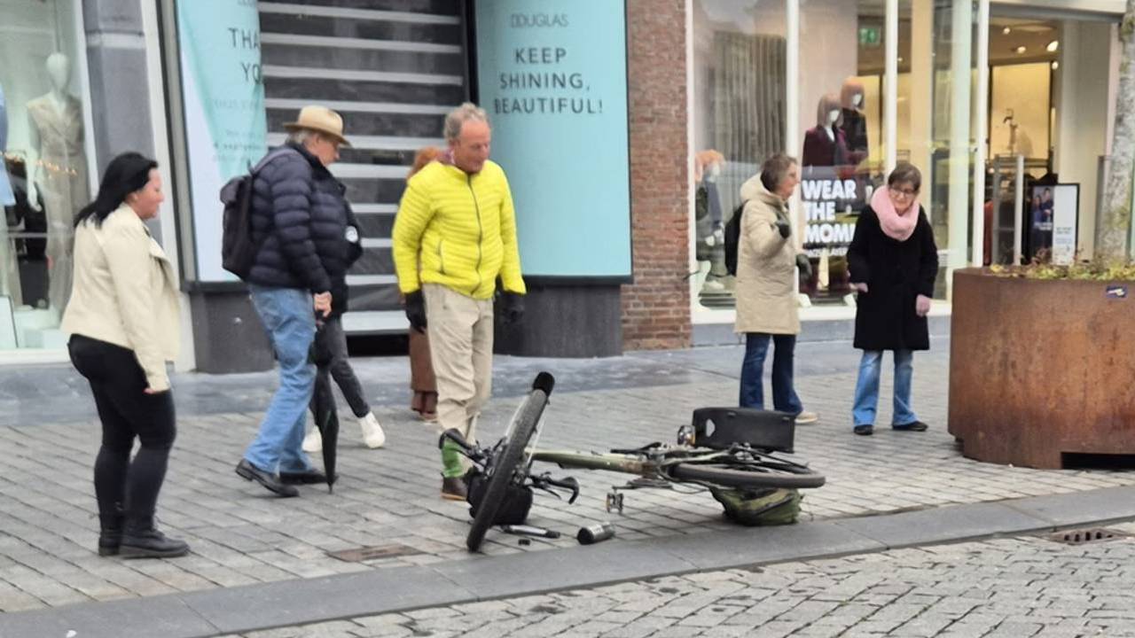 Man valt met fiets over gladden en schuine stoeprand aan de Markt (foto: Dtv Nieuws).