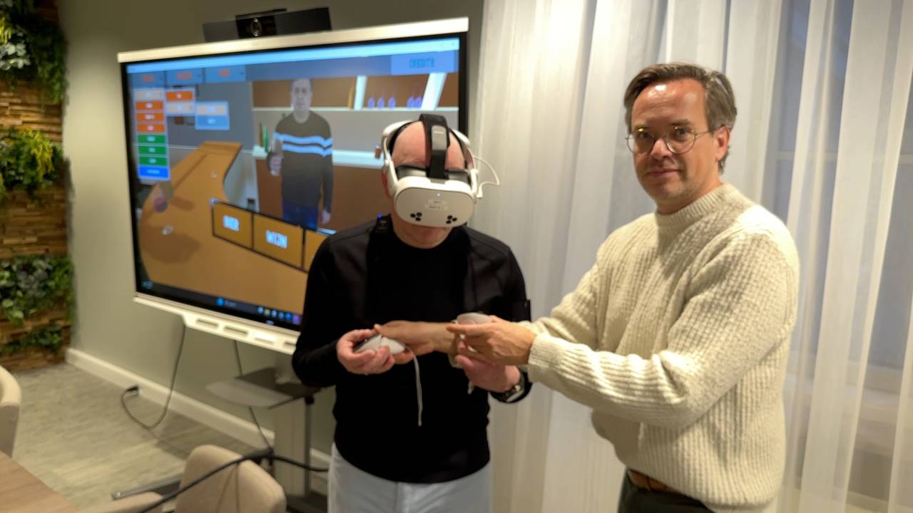 Onderzoeker Marnix van Gisbergen legt de VR-bril uit.