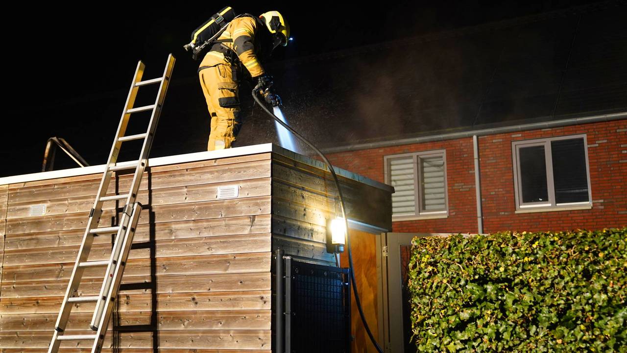 Een van de ingezette brandweerlieden op de dak van de schuur (foto: Bart Meesters/Persbureau Heitink).