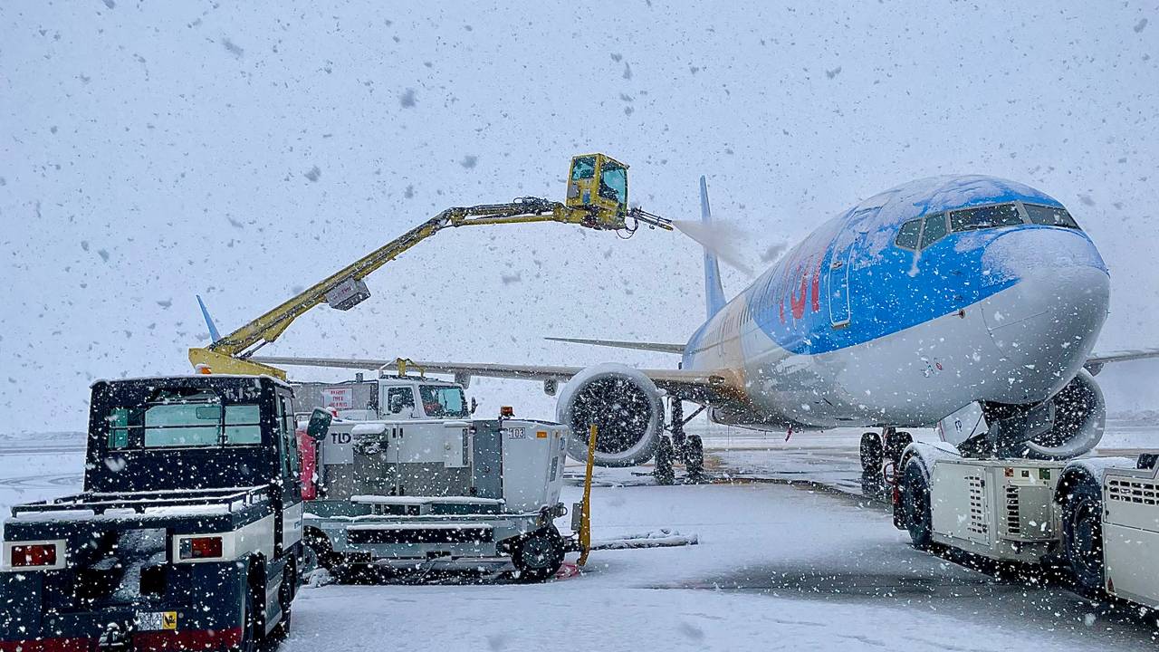 Een vliegtuig wordt in het winterse weer gereedgemaakt voor vertrek.