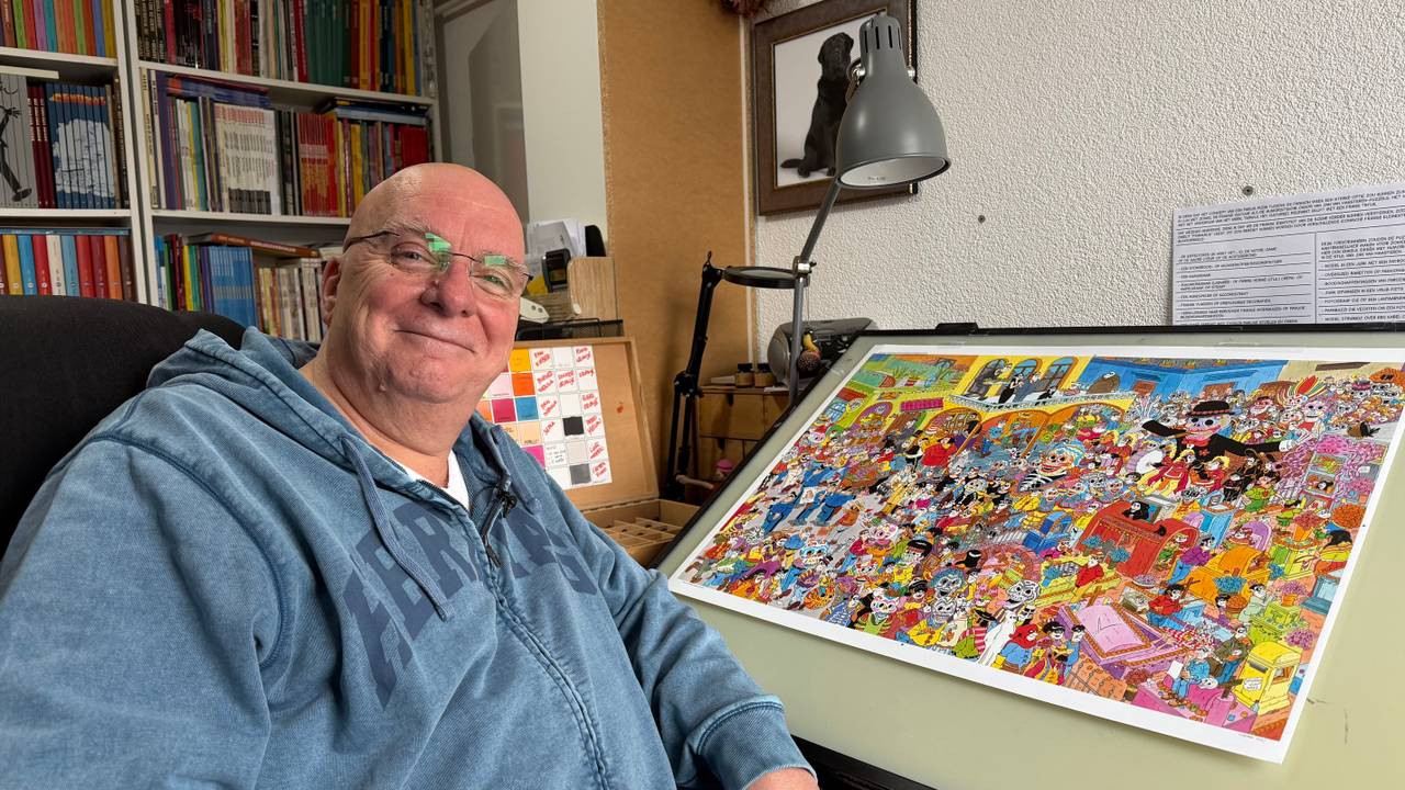 Tekenaar Dick Heins naast een van zijn ontwerpen voor de puzzels van Jan van Haasteren (foto: Ruud Ritzen).