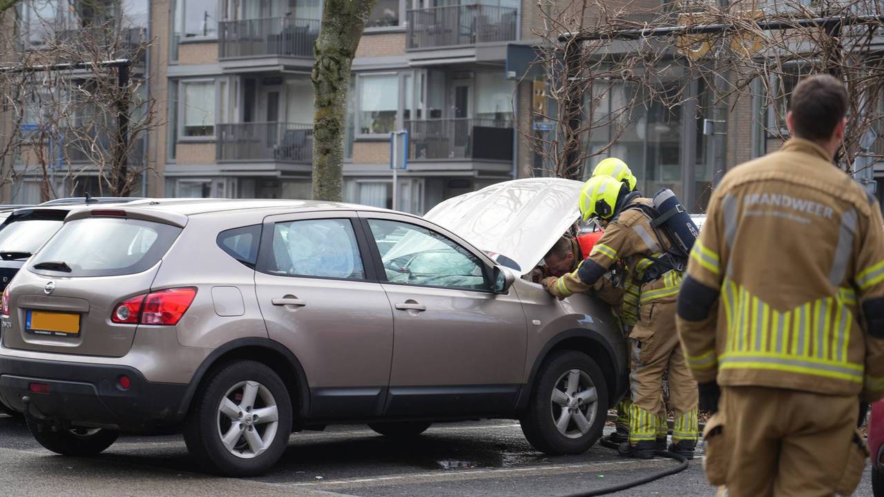 Brandweer blust een brand onder de motorkap van een geparkeerde auto (foto:Persbureau heitink/Jeroen Stuve).