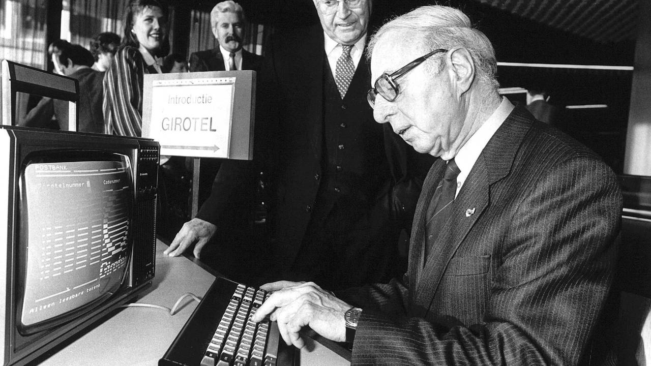 Oud-president directeur van de Nederlandse Bank, Jelle Zijlstra, bedient de terminal terwijl Postbank-directeur Phillip Leenman toekijkt (foto: ANP