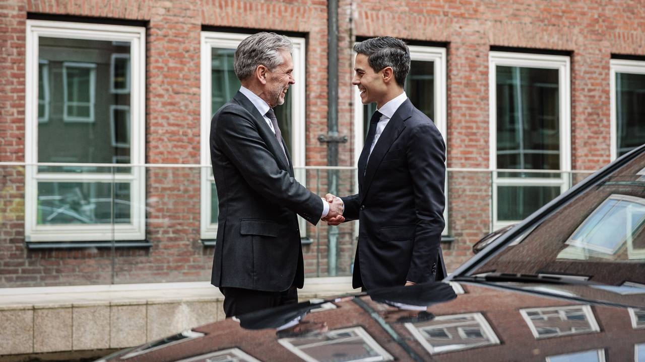 Dick Schoof en Rob Jetten groeten elkaar voor de ingang van het ministerie van Algemene Zaken (foto: ANP).