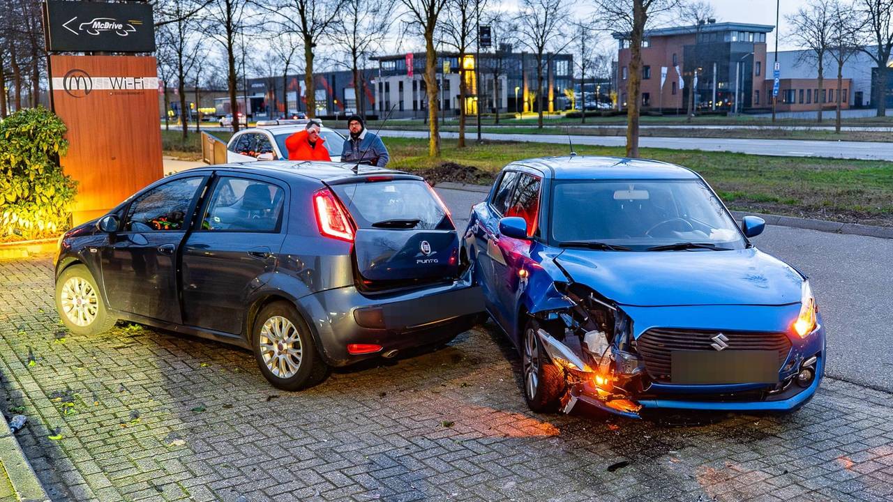 Auto ramt verkeersbord en twee geparkeerde auto's op parkeerplaats