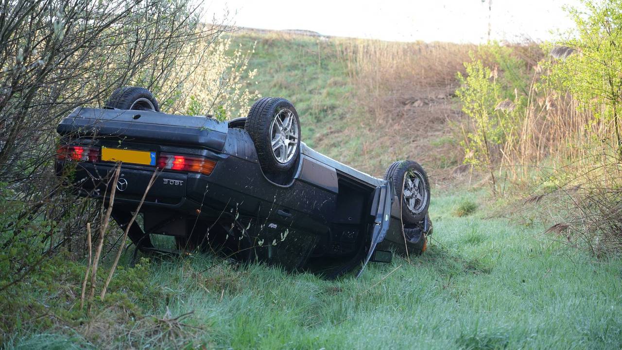 Auto rijdt van metershoog talud bij kruispunt in Dongen
