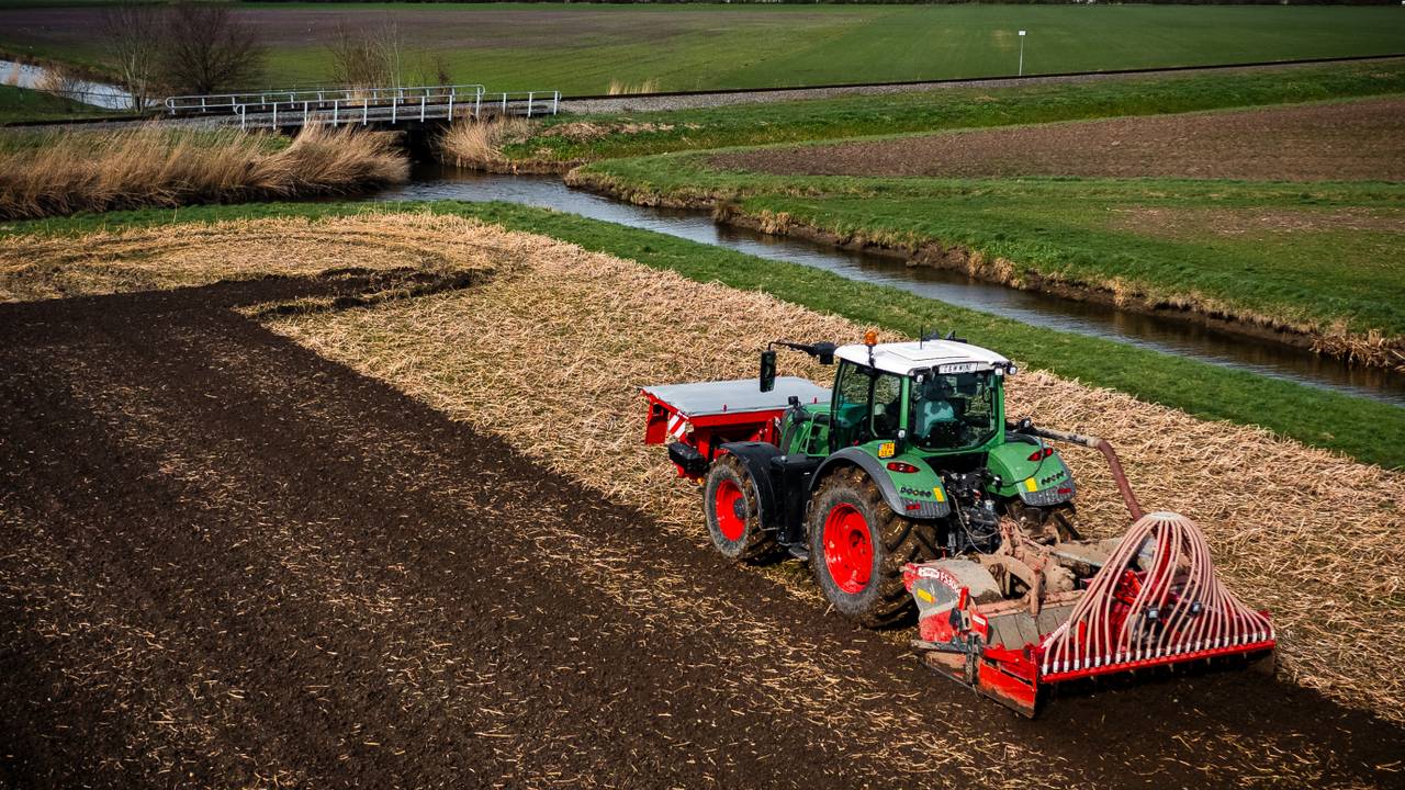 Ter illustratie: een boer die met een traktor zijn akker ploegt en bemest met kunstmest (foto: ANP).