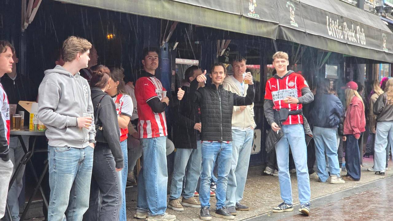 PSV-supporters schuilen na een flinke regenbui (foto: Noël van Hooft).
