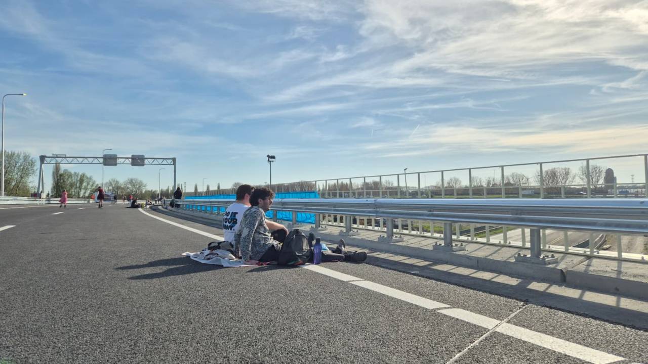 Douwe en Silvain genieten op de vluchtstrook van hun picknick (foto: Niek de Bruijn)