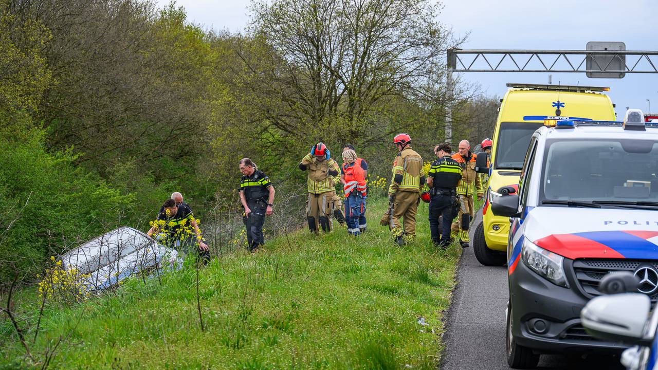 De man wilde niet uit zijn auto komen, agenten sloegen daarom de ruiten in. (Foto: Persbureau Heitink.)