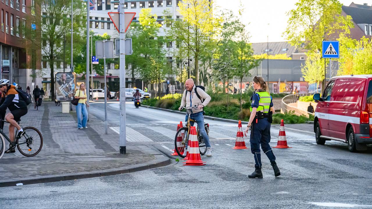 De handhaving wijst voorbijkomende fietsers op het spekgladde oliespoor. (Foto: Tom van der Put / Persbureau Heitink.)
