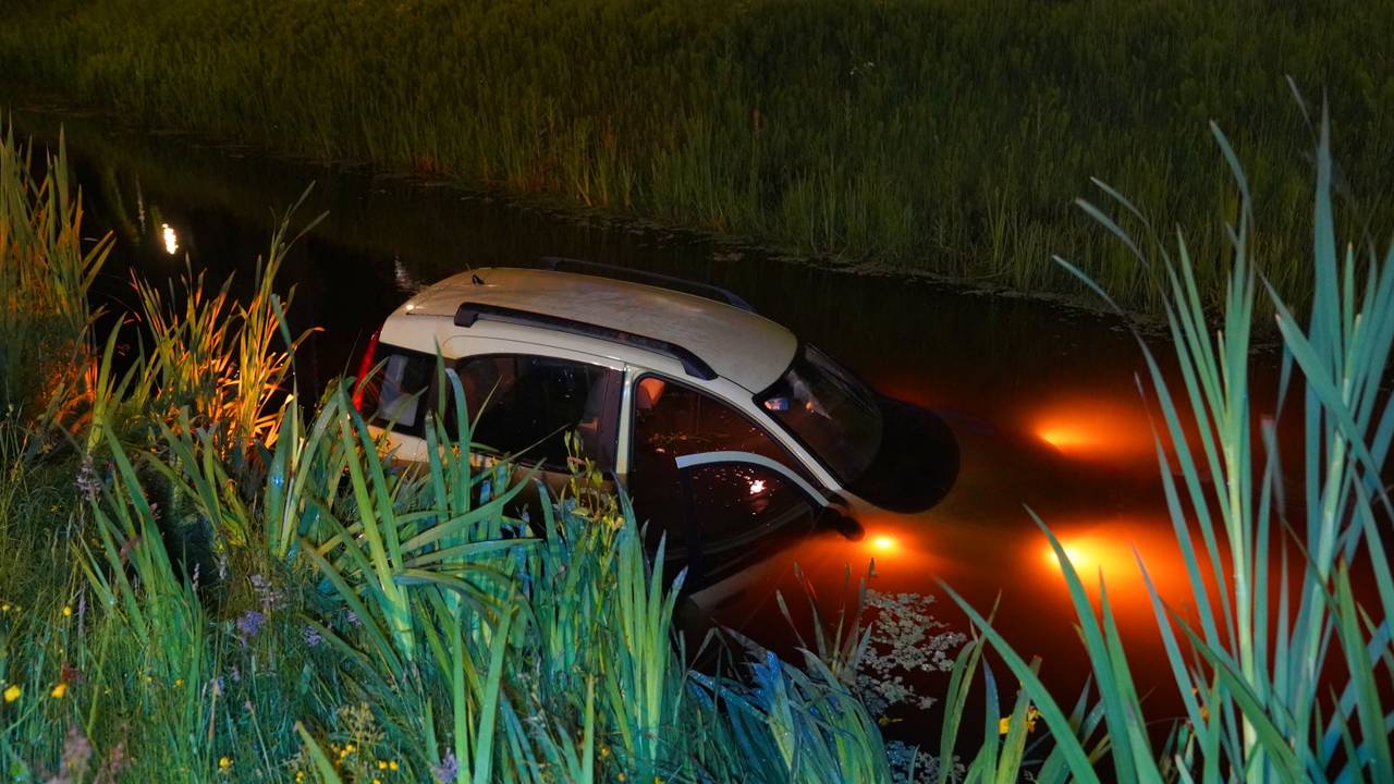 De auto maakte een flinke plons in de sloot, maar de bestuurder wist zelfstandig weer aan land te komen. (Foto: Bart Meesters / Persbureau Heitink.)