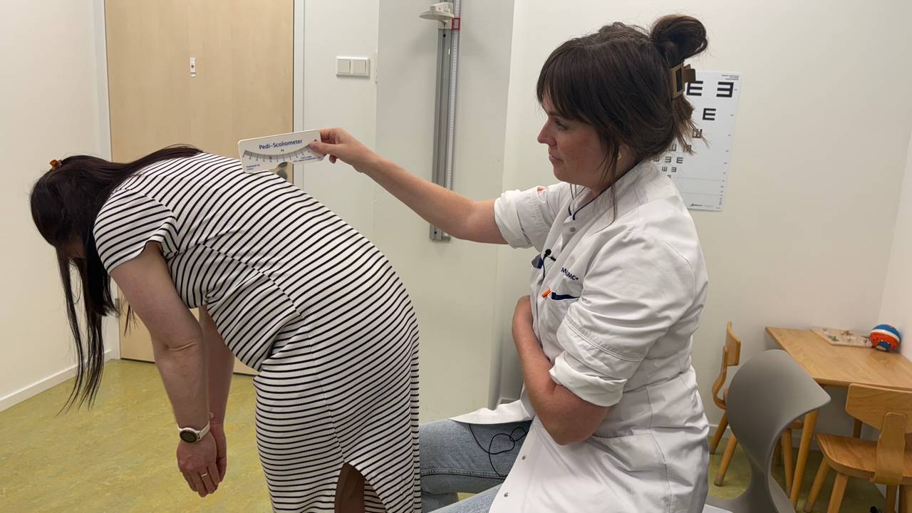 Bij een buktest meet orthopedisch chirurg Eva Jacobs (rechts) met een lineaal hoe scheef de rug groeit (foto: Omroep Brabant).