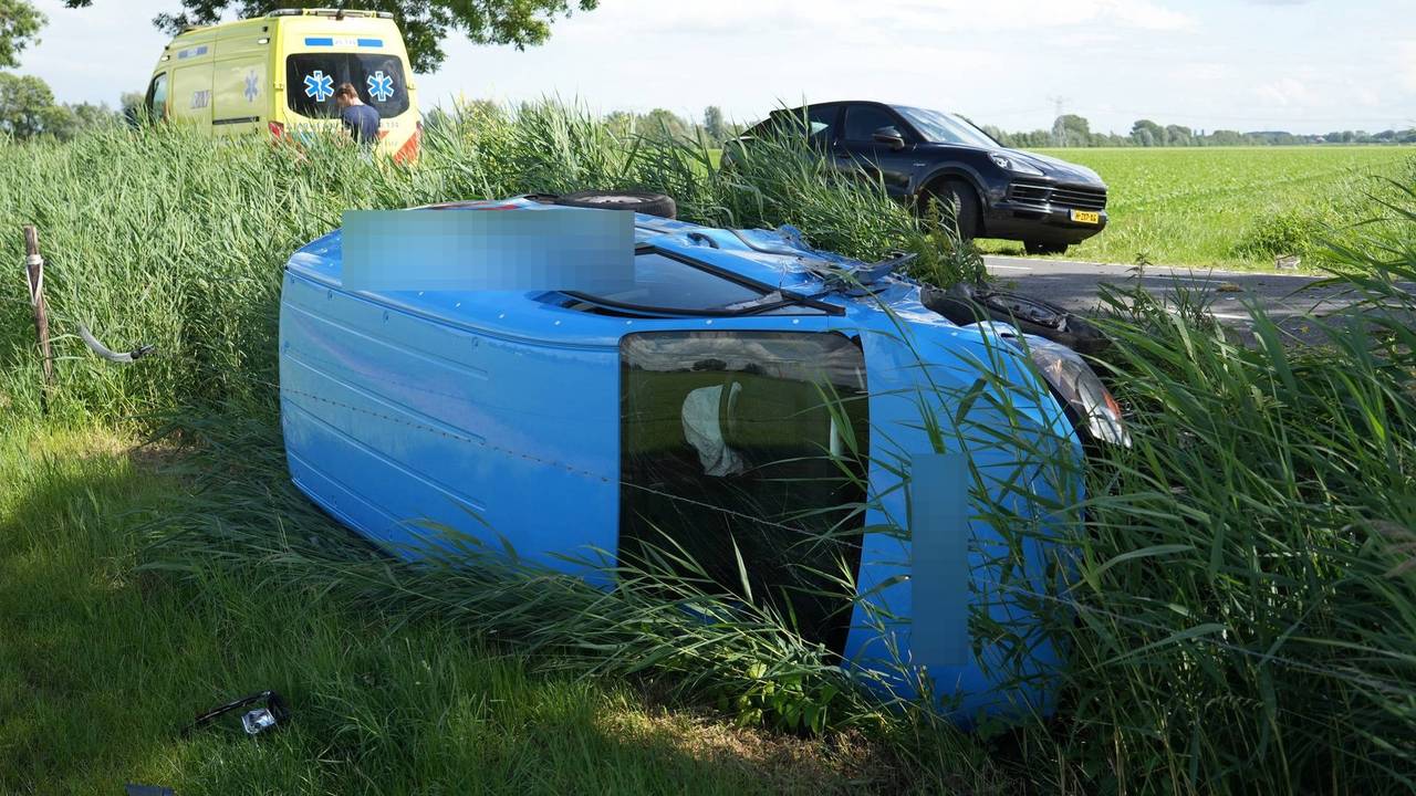 Een bestelbus belandde op zijn zijkant in een slot na een botsing met een auto in Raamsdonk (foto: Jeroen Stuve/Persbureau Heitink).
