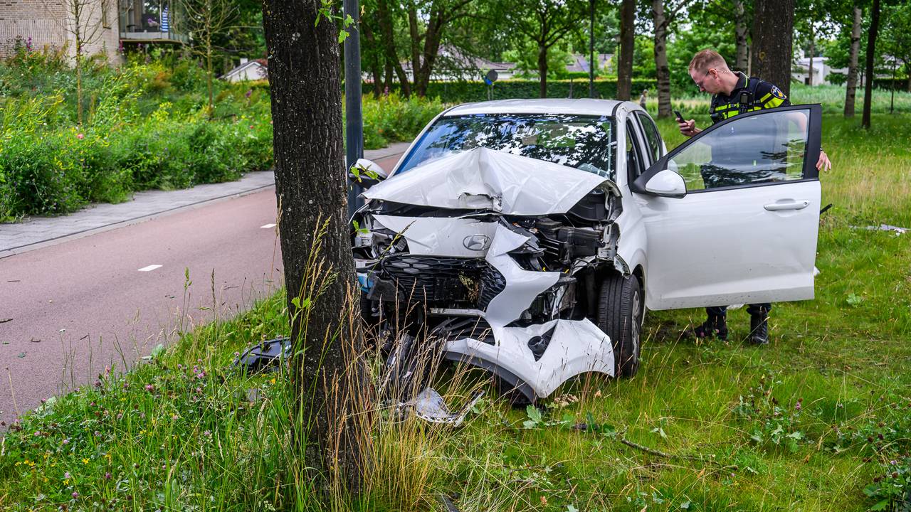 Auto slingert tegen een boom in Breda, de bestuurder is aangehouden na een blaastest (foto: Tom van der Put/Persbureau Heitink).