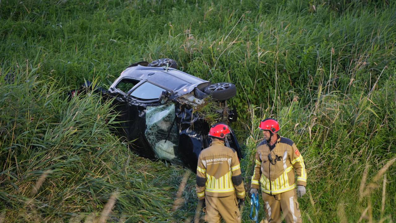 Een automobilist is zwaargewond geraakt nadat hij met z'n auto van een tien meter hoge dijk reed (foto: Erik Haverhals / Persbureau Heitink). 