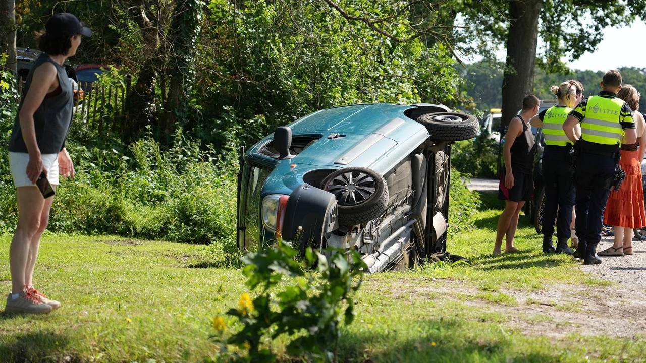 Auto belandt gekanteld in greppel, inzittenden uit auto geholpen