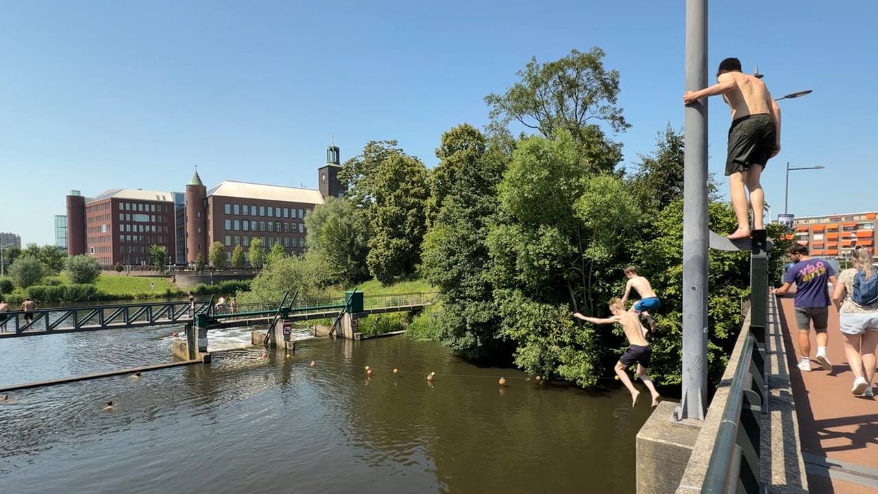 Jongeren springen in de Dommel in Den Bosch (foto: Jan Peels).