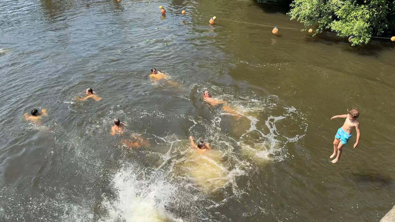 Jongeren springen in de Dommel in Den Bosch (foto: Jan Peels).