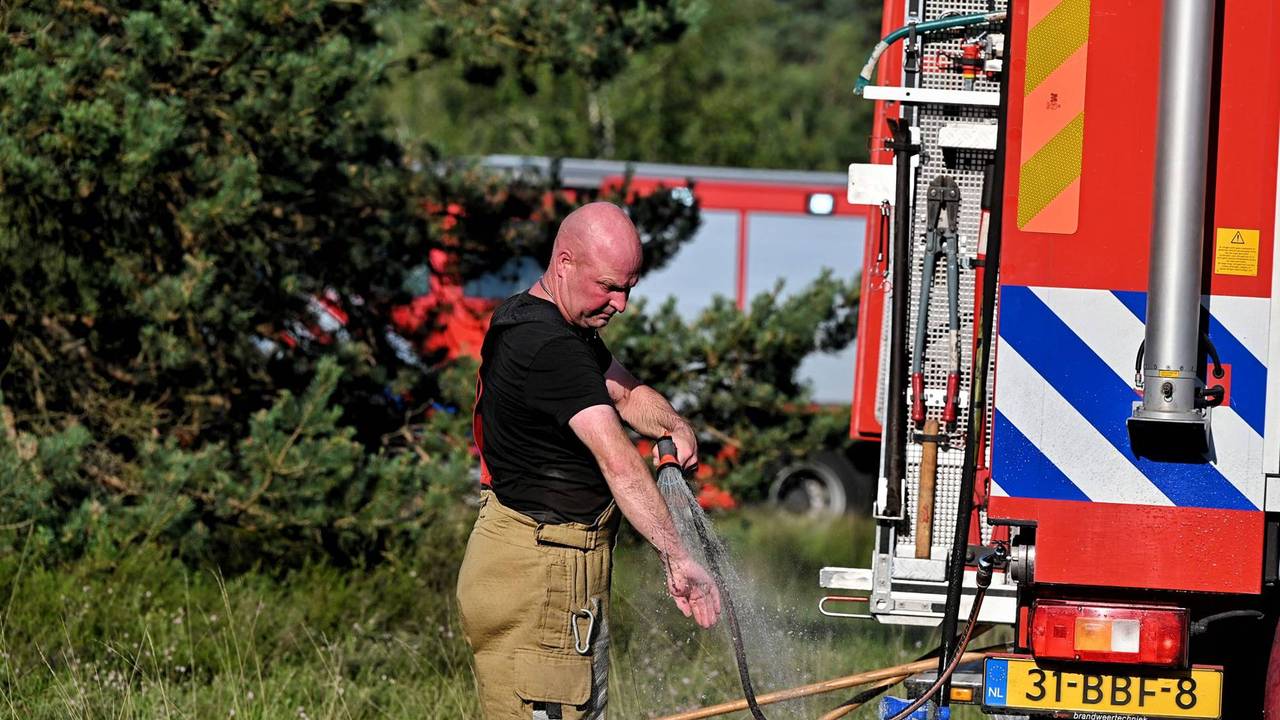 Ook de brandweerlieden zelf hadden verkoeling nodig na het blussen van de brand. (Foto: Toby de Kort / Persbureau Heitink.)