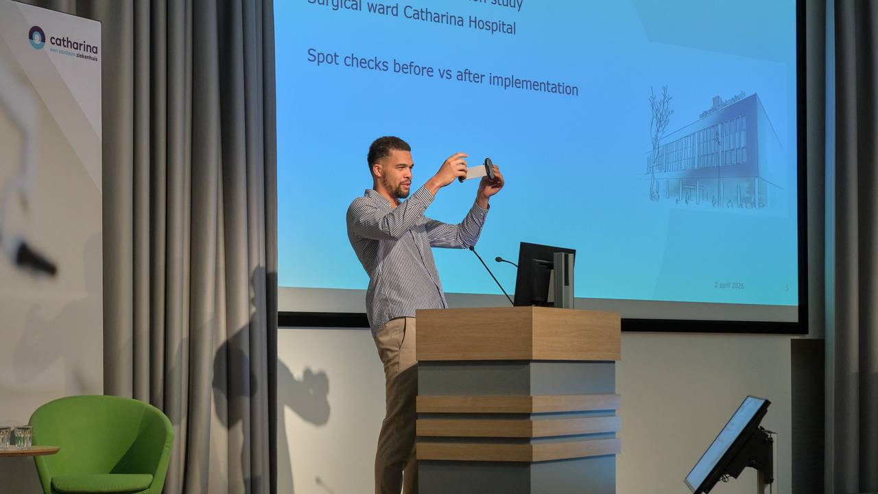 Ephrahim Jerry toont de armband op een congres (Foto: Jarno Verhoef/Catharina Ziekenhuis)