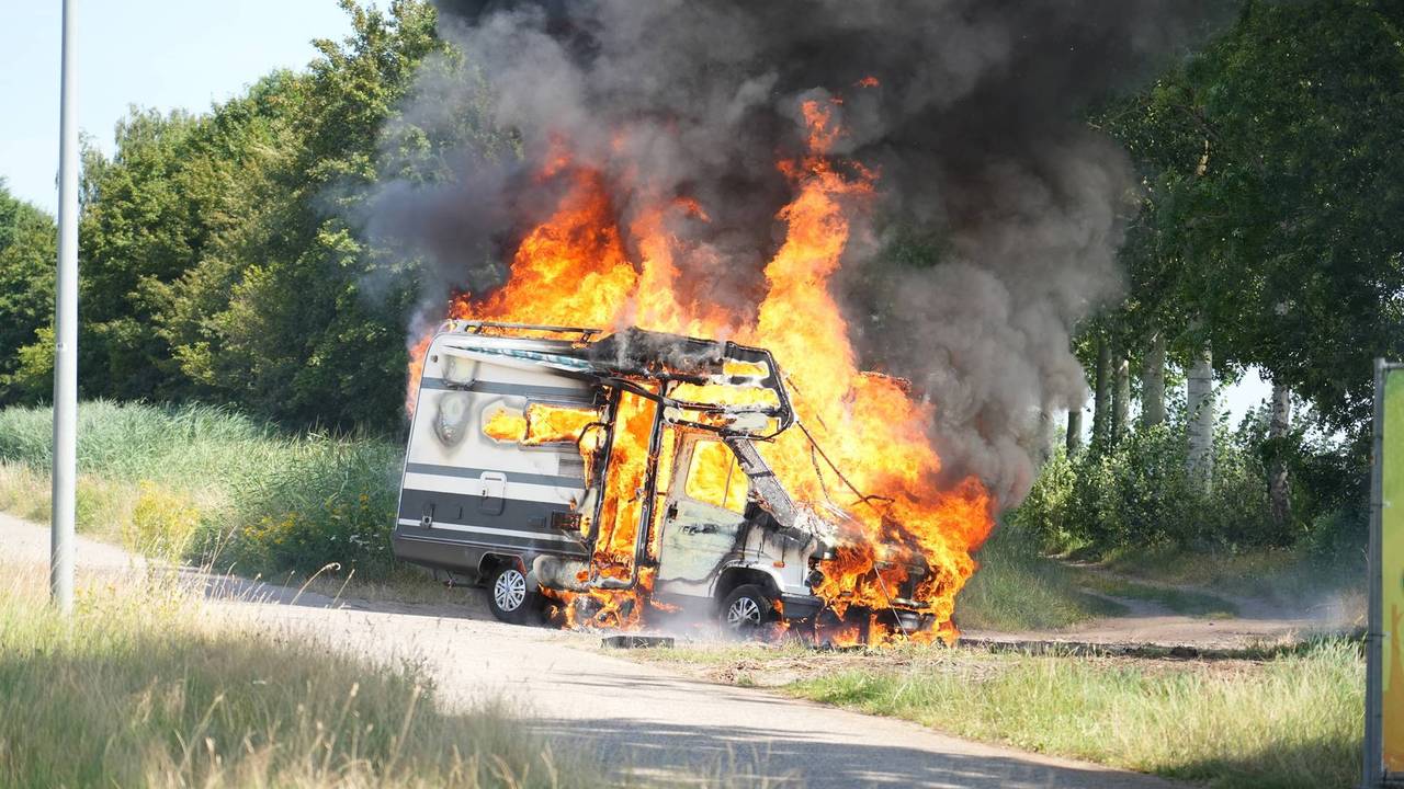 Vlammen slaan uit camper in Rijen, meerdere knallen te horen