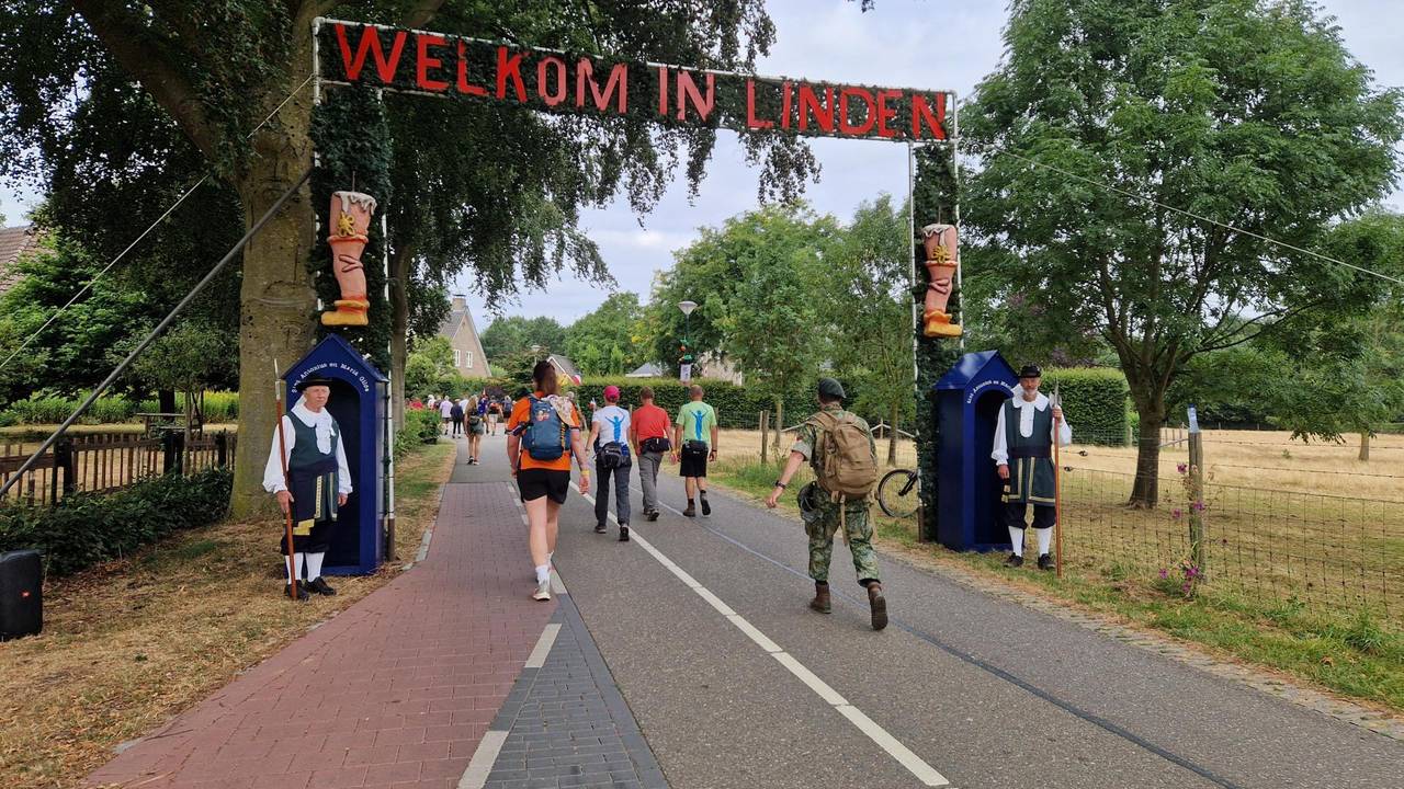 Twee poortwachters verwelkomen Vierdaagse-deelnemers in Linden.