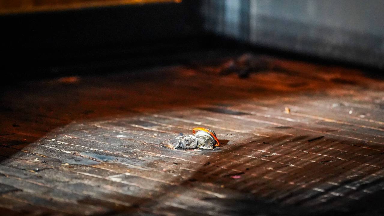 De resten van het flesje met brandversneller liggen nog voor de deur. (Foto: Persbureau Heitink.)