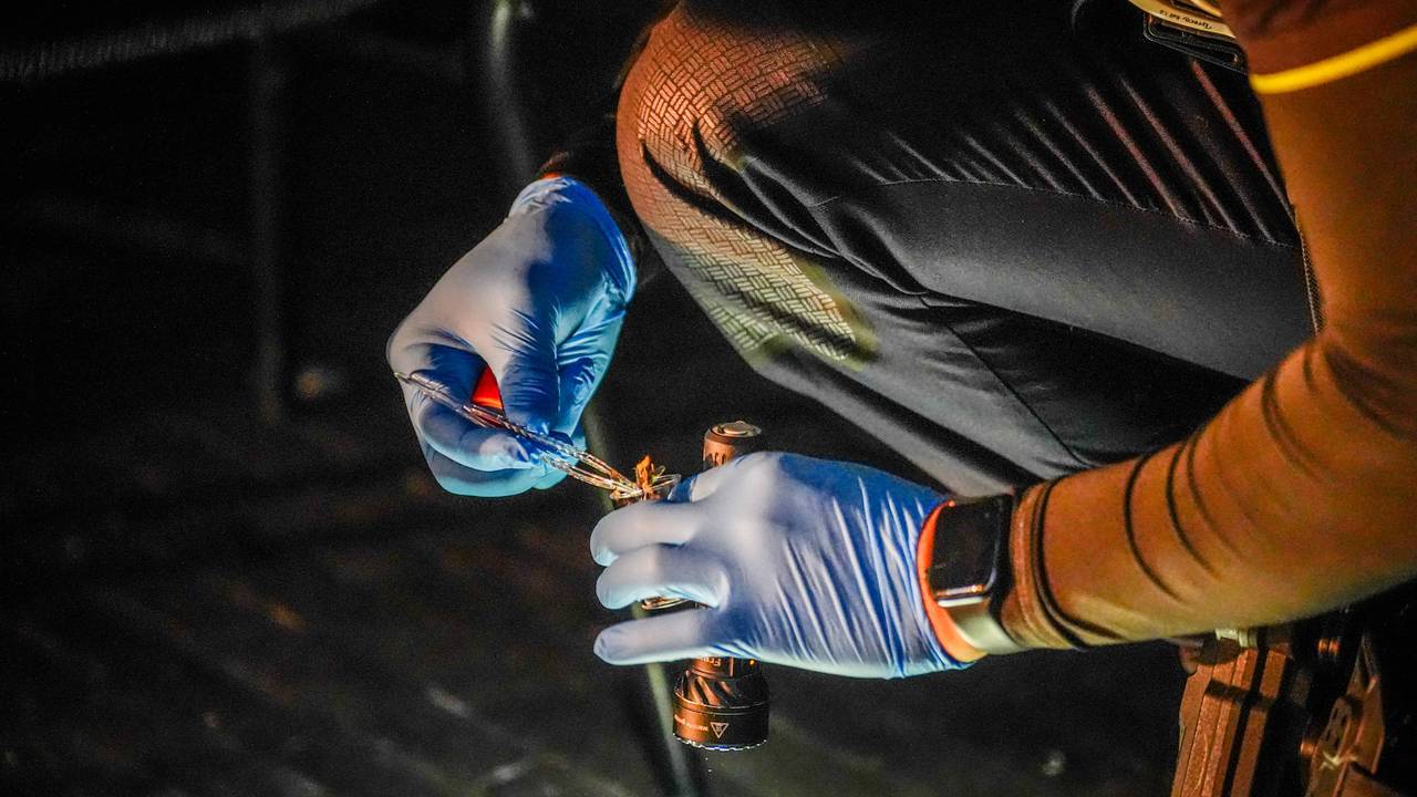 Een agent verzamelt stukjes van het zware vuurwerk. (Foto: Persbureau Heitink.)