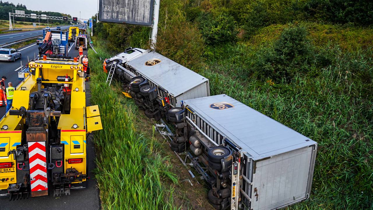 A67 dicht, vrachtwagen schiet over vangrail en kantelt op wal