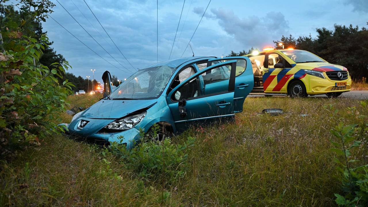 Auto meerdere keren over de kop op N260 bij Tilburg door laagstaande zon (foto: Toby de Kort / Persbureau Heitink).