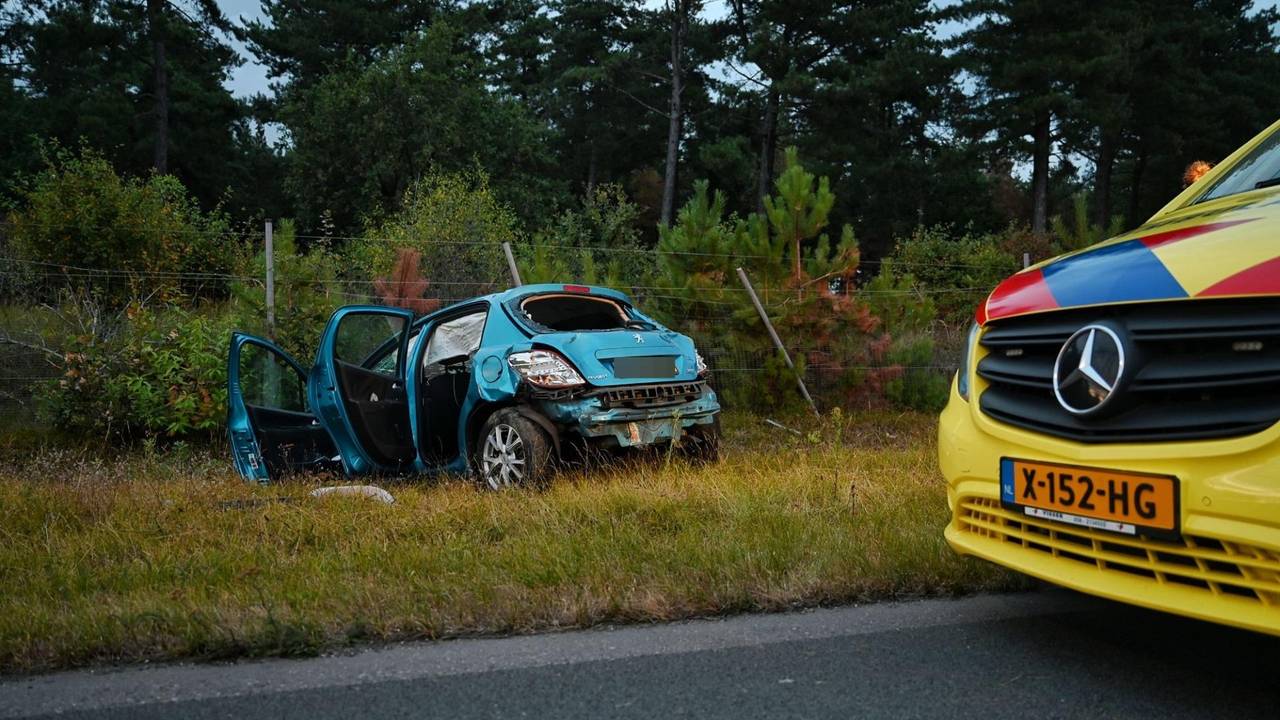 Auto meerdere keren over de kop op N260 bij Tilburg door laagstaande zon (foto: Toby de Kort / Persbureau Heitink).