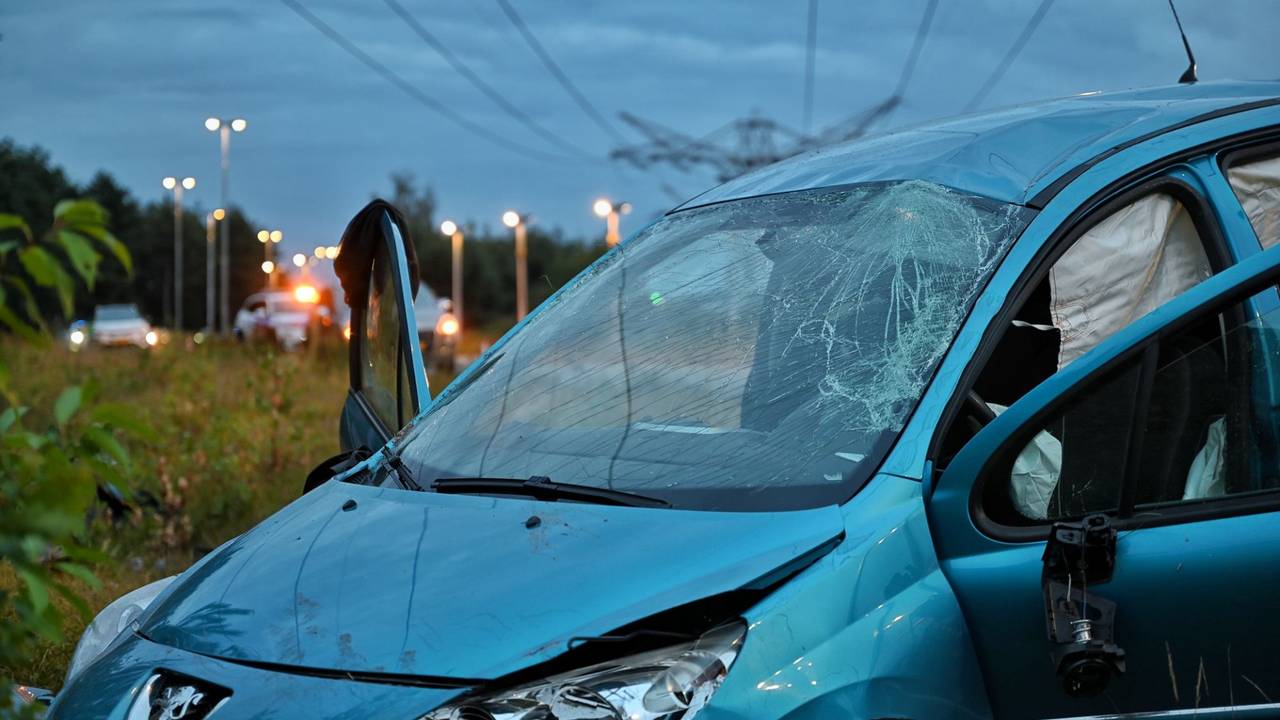Auto meerdere keren over de kop op N260 bij Tilburg door laagstaande zon (foto: Toby de Kort / Persbureau Heitink).