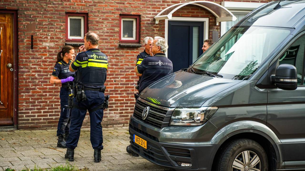 Politieagenten staan voor de woning waar de dode man werd aangetroffen. (Foto: Dave Hendriks / Persbureau Heitink.)