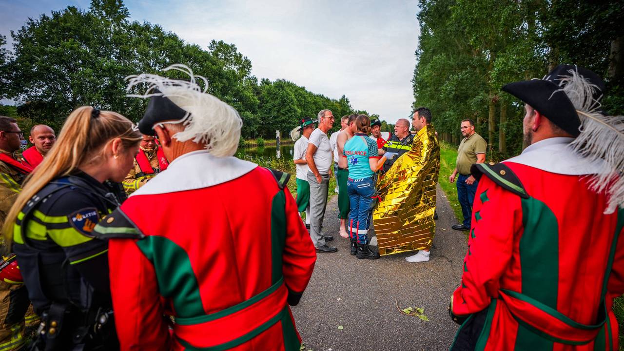 De leden die in het kanaal sprongen worden opgevangen door het ambulancepersoneel met een warmtedeken. (Foto: Persbureau Heitink.)