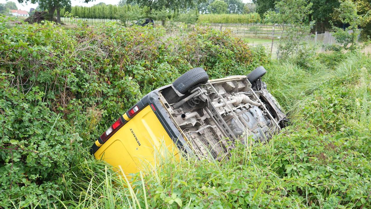 Pakketbezorger belandt met bus op z'n kop in de sloot in Dongen