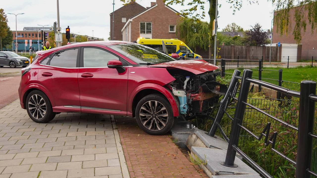 Auto rijdt stoplicht omver en komt tegen hek tot stilstand in Helmond