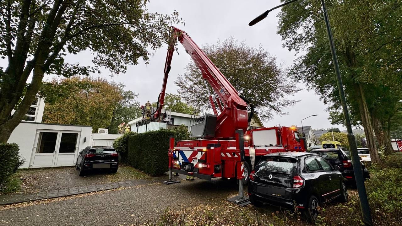 Brandweer haalt een gewonde man met een hoogwerker van het dak van een carport aan de Wildert in Dorst (foto: Jeroen Stuve/Persbureau Heitink).