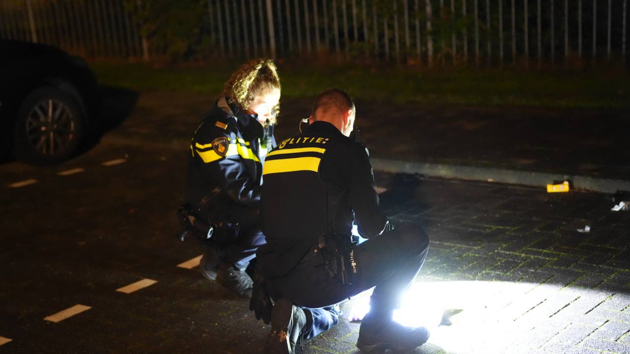 Politieagenten zoeken naar kogelhulzen (foto: Erik Haverhals/Persbureau Heitink).