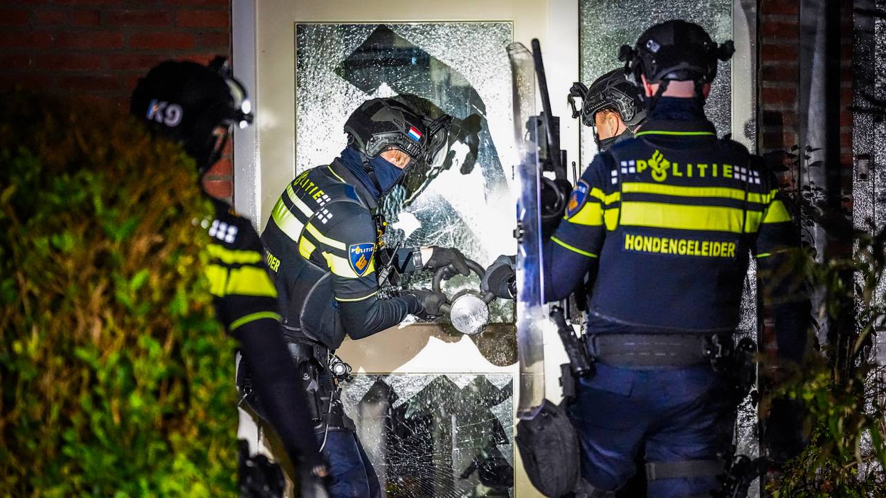 Agenten forceren de deur van een huis in Valkenswaard in de zoektocht naar een verdachte (foto: SQ Vision). 