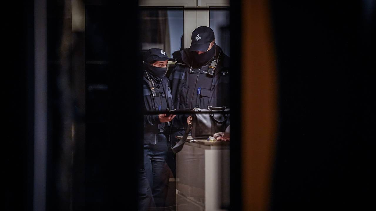 Politie zaagt gat in voordeur van huis bij inval in Eindhoven (foto: SQ Vision).