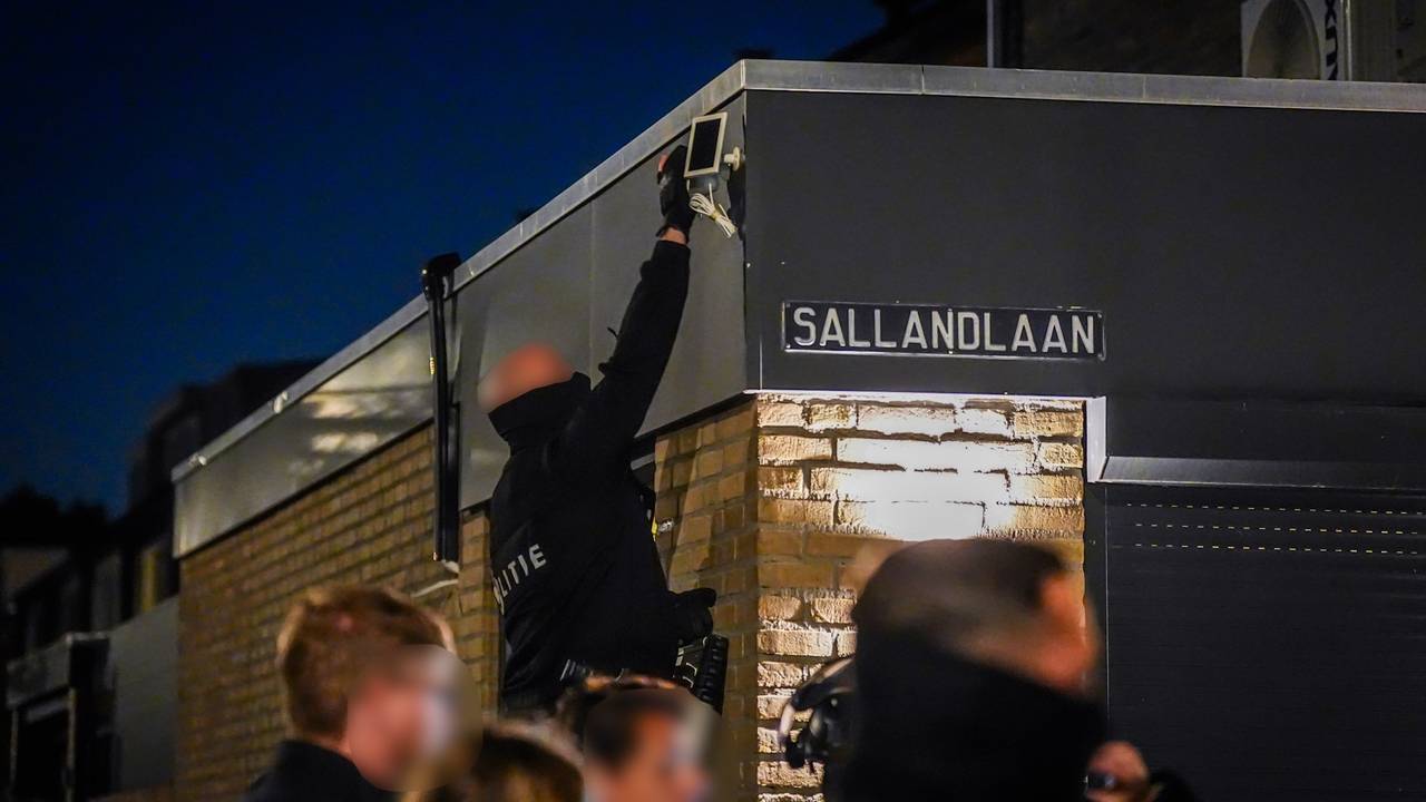 Politie zaagt gat in voordeur van huis bij inval in Eindhoven (foto: SQ Vision).