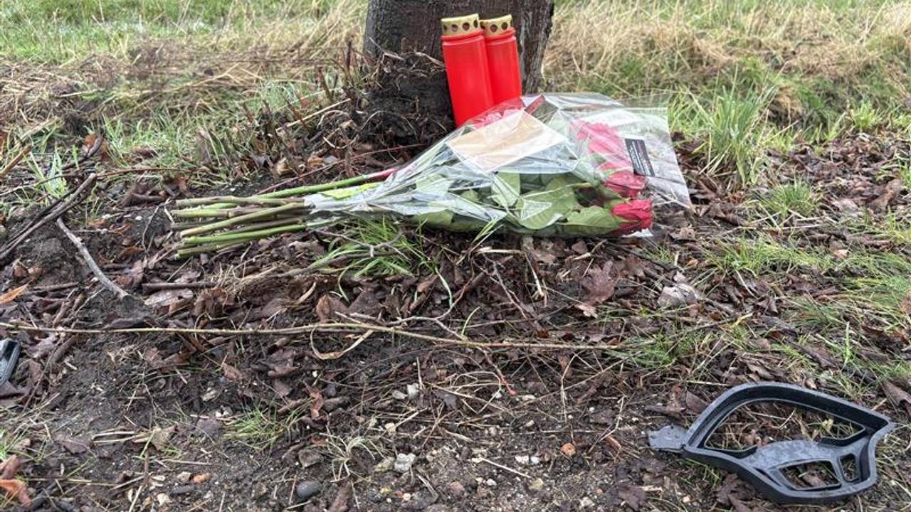 Een bosje bloemen, twee kaarsjes en een auto-onderdeel zijn de stille getuigen van het fatale ongeval aan de Peeldijk in Beek en Donk waarbij een 23-jarige scooterrijdster om het leven kwam (foto: Wilco Zonneveld). 