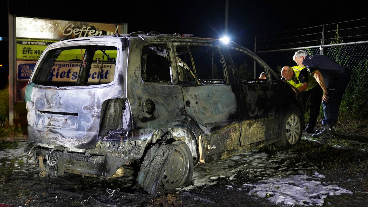 De politie onderzoekt de uitgebrande auto in Geffen (foto: Bart Meesters/Persbureau Heitink).