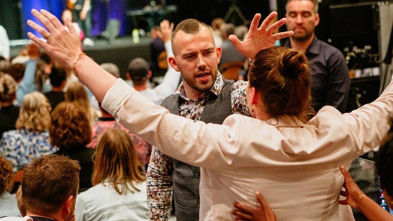 Tom de Wal die bidt voor een vrouw (Foto: Facebook Frontrunners Ministries).