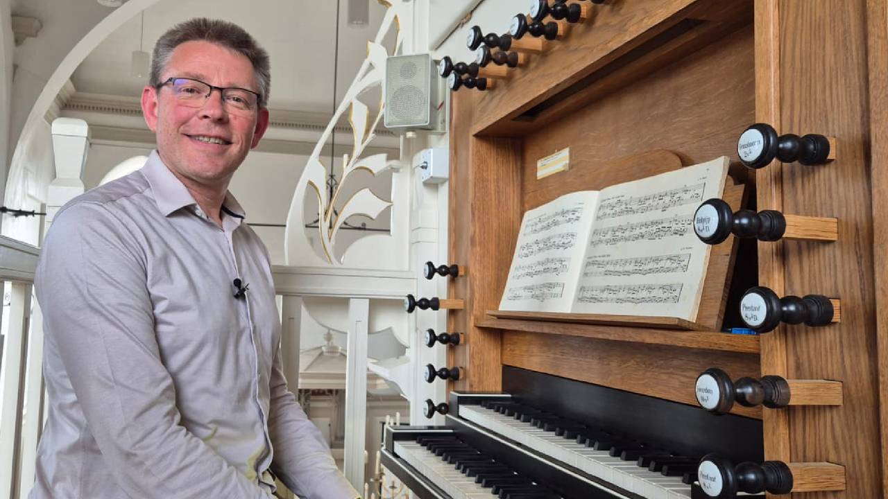 Organist Aad de Ligt achter het defecte orgel in de Protestantse Kerk in Hooge Zwaluwe (foto: Niek de Bruijn)