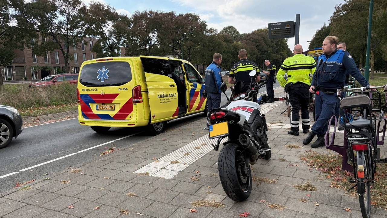 Ambulancemedewerkers buigen zich over de motorrijder (foto: Jeroen Stuve/Persbureau Heitink).